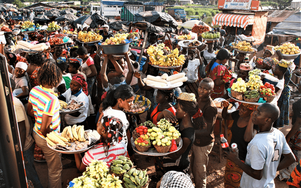 Menschen tragen bunte Körbe mit frischen Früchten auf einem belebten Markt in Abidjan. | © GIZ Toni-Kaatz-Dubberke