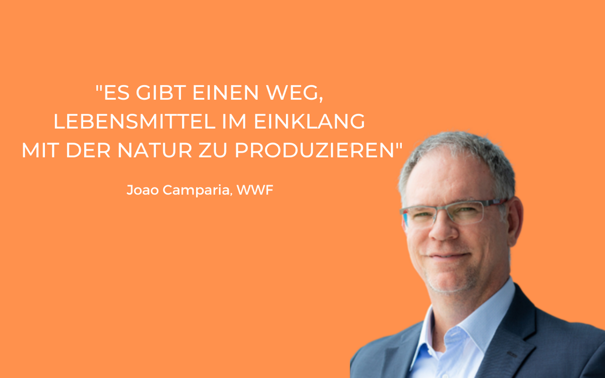 Ein Mann in Anzug steht vor orangefarbenem Hintergrund mit einem Zitat über nachhaltige Lebensmittelproduktion.
