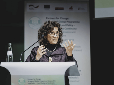 Eine Frau spricht gestikulierend auf einer Podiumsdiskussion während der GIZ Land Week 2025.