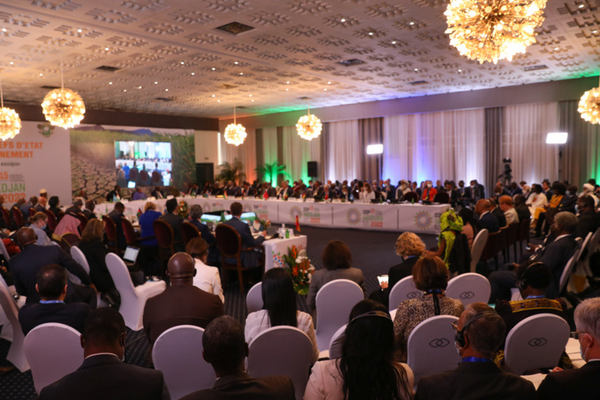Delegierte sitzen in einem großen Konferenzraum bei der UNCCD COP15 in Abidjan, um Umweltstrategien zu diskutieren.