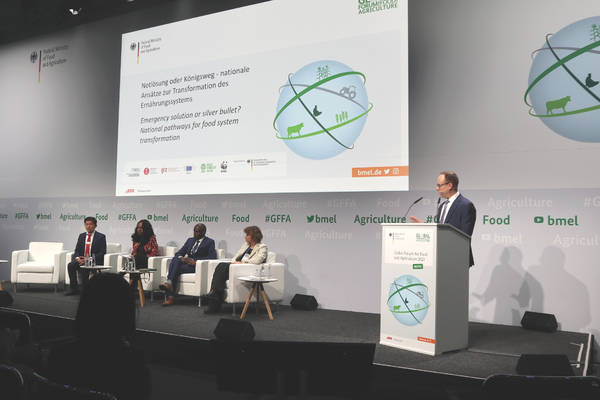 Ein Redner spricht auf einem Podium vor einem Panel beim Global Forum für Ernährung und Landwirtschaft 2023.