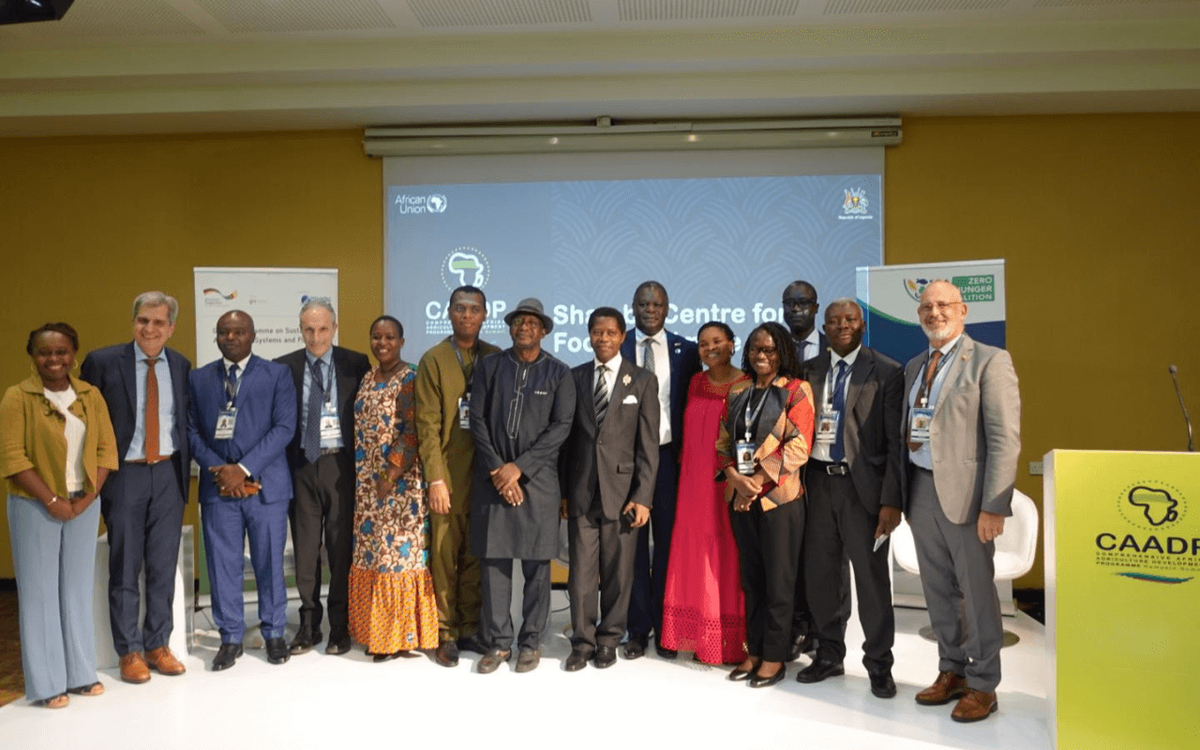 Eine Gruppe von Menschen posiert vor einem Projektorbildschirm bei einer Konferenz des CAADP für Ernährungssicherheit.