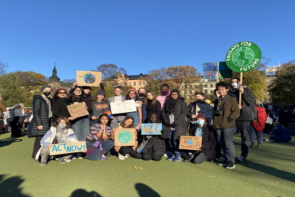 Eine Gruppe von Menschen versammelt sich in Stockholm mit Schildern von Fridays for Future, um für Klimaschutz zu demonstrieren.