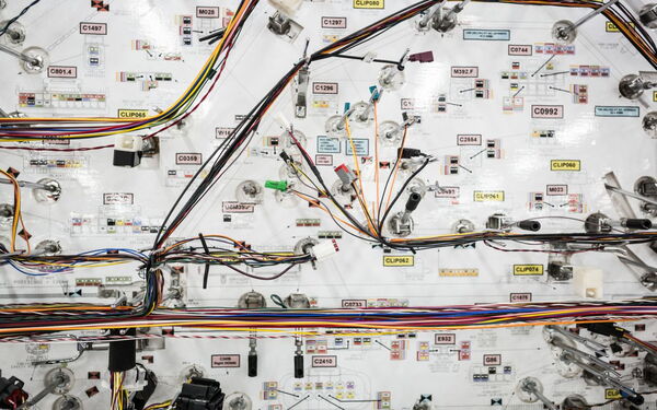 Ein komplexes Netzwerk aus farbigen Kabeln und Schaltern ist auf einem technischen Schaltplan angeordnet.