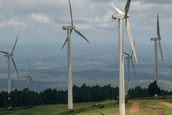Windkraftanlagen drehen sich in einer ländlichen Landschaft unter bewölktem Himmel und erzeugen grüne Energie.