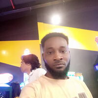 Ein Mann macht ein Selfie in einer bunt beleuchteten Umgebung, während eine andere Person im Hintergrund steht.