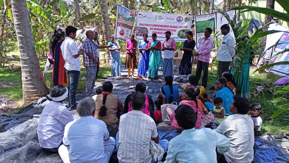 A group of farmers participates in a training session on agroecological methods, focusing on seed treatment.